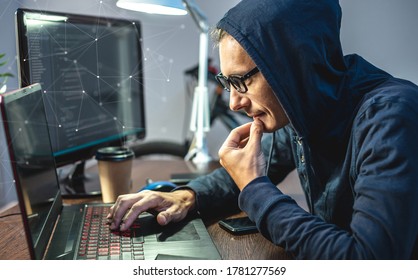 Man hacker in a hood are programming virus code on a laptop. The concept of Internet fraud and personal data hacking