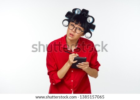 man with hair curlers in red shirt writes in a notebook                              