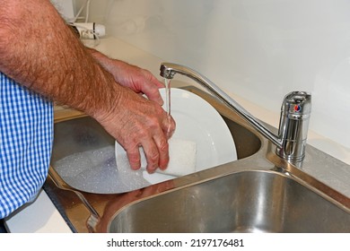 Man With Hairy Arms Washing A Dish In The Sink