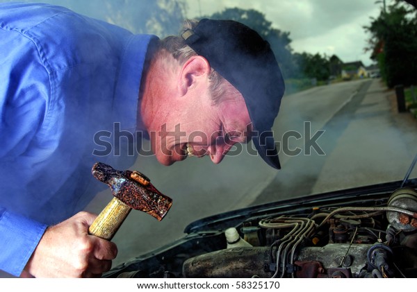 man with a hammer trying to smash his broken down\
car at night