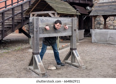 A man hammered out by middleage torture device - pillory