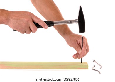 Man hammering  nail into a board, isolated on a white background