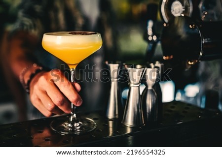 man hand bartender holding cocktail in glass on the bar counter