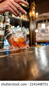 man hand bartender making glass negroni cocktail in bar - Shutterstock ID 2141448751