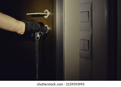 Man Hand In A Black Glove Opens The Office Door In The Night Light Of A Flashlight