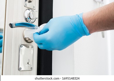 Man Hand In Blue Gloves Cleaning Door Knob With Disposable Napkin. Coronavirus Quarantine Time. Misophobia. Male Hand Washes House In Disgust. Covid-19