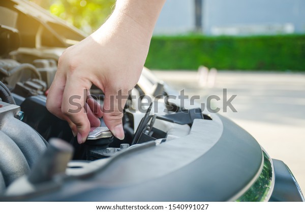 Man hand checking level\
of coolant car engine. Check and maintenance the coolant in car\
with yourself.