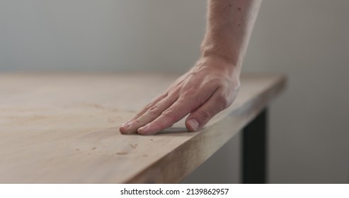 man hand checking sanded black walnut wood table - Powered by Shutterstock