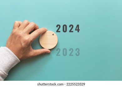 Man hand choose number 2024 on blue background. countdown to 2024. Start concept