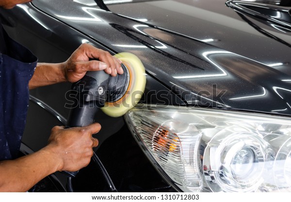 man hand cleaning the car with polishing and\
waxing.polishing of the car will help eliminate contaminants on the\
surface of the car.