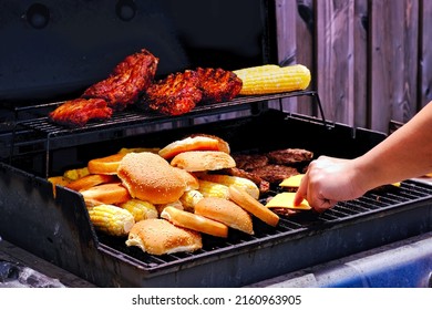 Man Hand Cooking Beef Cheese Burgers On Hot Grill At Backyard. Summer House Party And Fun Friends Family Gathering Event Background.