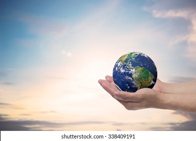 man hand gesture holding the world over blur sky background for save the world concept.Elements of this image furnished by NASA