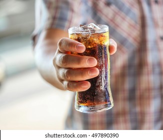 Man Hand Giving Glass Of Sparkling Water,Soft Drinks With Ice