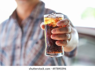 Man Hand Giving Glass Of Sparkling Water,Soft Drinks With Ice.