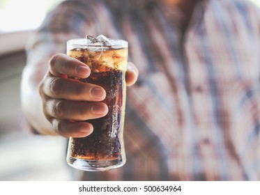 Man Hand Giving Glass Of Sparkling Water,Soft Drinks With Ice.