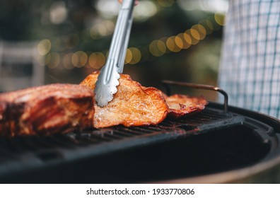 Man Hand Grilling Barbecue On Fire At Backyard On Day. Family Dinner Outdoor Style Bbq Activity.