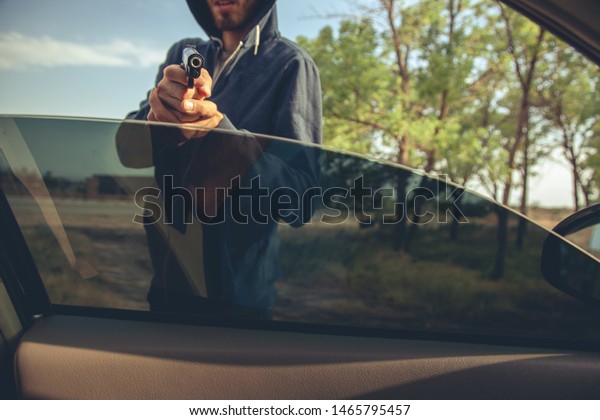 man hand gun in car in
nature