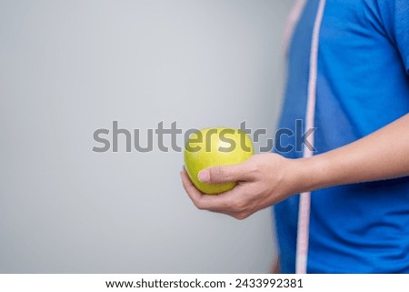 man hand hold Donut with tape measure, choose stop eating sweet is Unhealthy ealthy food. Dieting control, Weight loss, Obesity, eating lifestyle and nutrition concepts