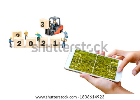 man hand hold and touch screen smartphone or cellphone isolated on white with football field on screen ,abstract background.
