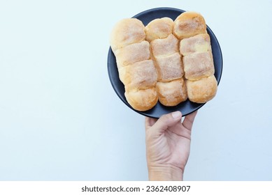 man hand holdind a Delicious Freshly baked sweet bun Butter,brown butter bread luscious with sugar isolated on white backdrop
