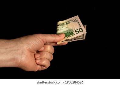 Man Hand Holding 50 Dollars In Hand On Black Isolated Background