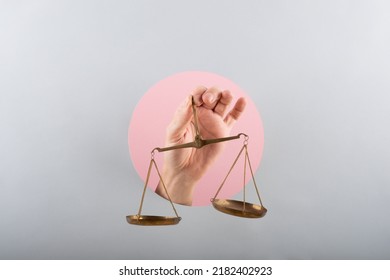 mano de hombre con un balance en fondo rosa y azul
