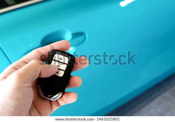 Man hand holding the car remote, he push the
remote control to open the car
door