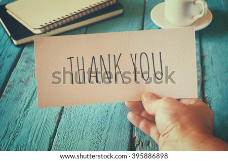 man hand holding card with the word thank you. retro style image