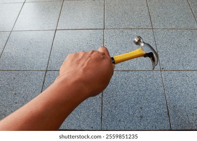 Man hand holding a claw hammer, showcasing the classic tool for industrial manual labor, ideal for construction, woodworking, and repair tasks - Powered by Shutterstock