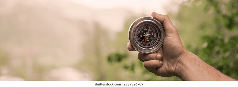 man hand holding  compass in nature - Shutterstock ID 2339326709