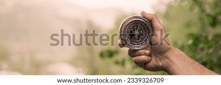 man hand holding  compass in nature
