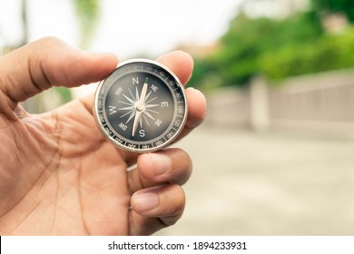 Man Hand Holding Compass On City And Car Blurred Background Using Wallpaper Or Background Travel Or Navigator Image.