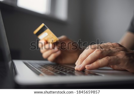 Man hand holding credit card and using laptop at home. Businessman or entrepreneur working in office. Online shopping, internet banking, store online, payment, spending money, e-commerce concept