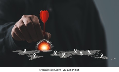 Man hand holding darts with world map. Connecting global travel location technology, Destination points. Map pointer navigation concept, pointing at target of business plan concept, GPS navigator.