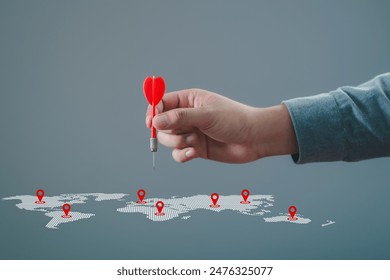 Man hand holding darts with world map. Connecting global travel location technology, Destination points. Map pointer navigation concept, pointing at target of business plan concept, GPS navigator. - Powered by Shutterstock