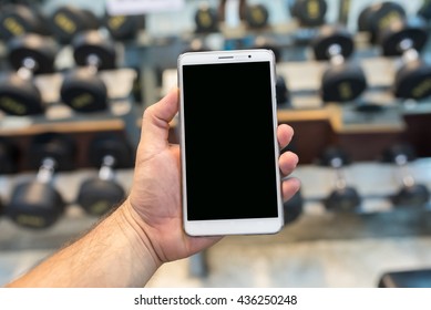 Man Hand Holding Empty Screen Of Smart Phone In Gym.