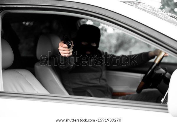 man hand holding gun in\
car\

