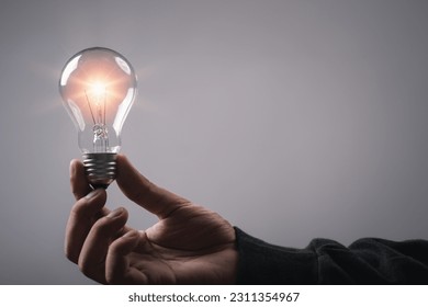 Man hand holding light bulb brain metaverse technology icon, studio shot. Virtual gadgets for entertainment, work, free time and study. Idea creative by using phone concept. - Shutterstock ID 2311354967