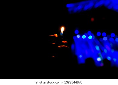 Man Hand Holding A Lighter In A Night Concert Performance. Fun And Lifestyle Outdoors