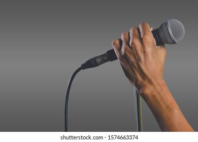 Man Hand Holding A Microphone On A Stand. The Microphone Clipping Path.