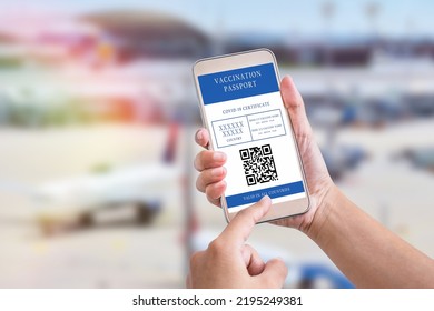 Man Hand Holding Mobile Phone And Displaying Valid Digital Vaccination Certificate For COVID-19 In Airport Background. Vaccination, Disease Immunity Passport, Health And Surveillance Concepts
