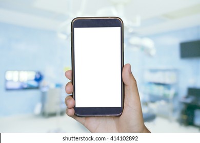 Man hand holding mobile smart phone , tablet,cellphone over Blur of Blur of equipment and medical devices in modern operating room take with art lighting and blue filter,operating room equipment. - Powered by Shutterstock