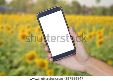 Man hand holding mobile smart phone , tablet,cellphone over Blur backgrond  of sun flower with.shopping online concept.vintage photo color