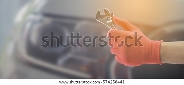 Man hand
holding mobile smart phone Contact Car repairing,Hand of car
technician auto mechanic with a wrench working in garage. service
in auto repair station.vintage tone,for
banner