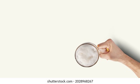 Man Hand Holding Mug Full Of Beer On White Background. Isolated top up view. - Shutterstock ID 2028968267