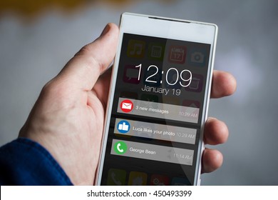 man hand holding notifications smartphone. All screen graphics are made up.