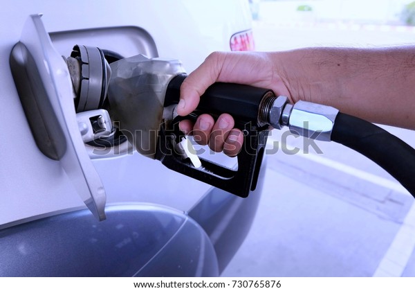 Man hand is holding\
the oil dispenser.