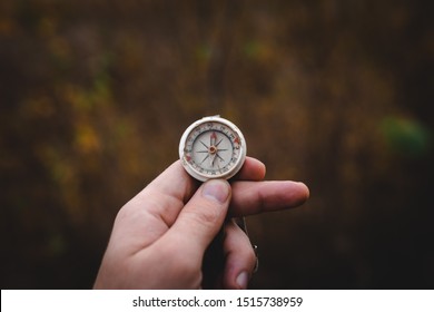 Man hand holding a old compass with broken glass. Travel concept, path selection, navigation, tourism, hiking. Autumn background. crack on the glass as disappointment and cancellation of plans. - Shutterstock ID 1515738959