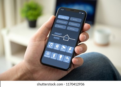 man hand holding phone with app smart home in room house - Powered by Shutterstock