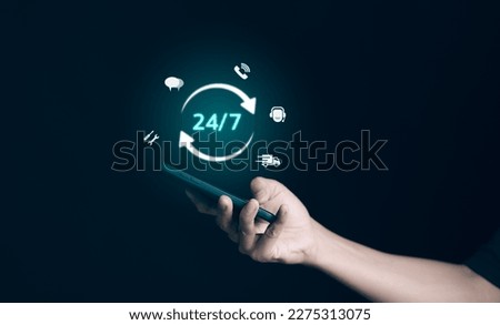 Man hand holding phone with icon virtual 24-7 on for worldwide nonstop and full-time available contact of service concept. Assistance customer services, deliver, and Nonstop service 24 hr concept.